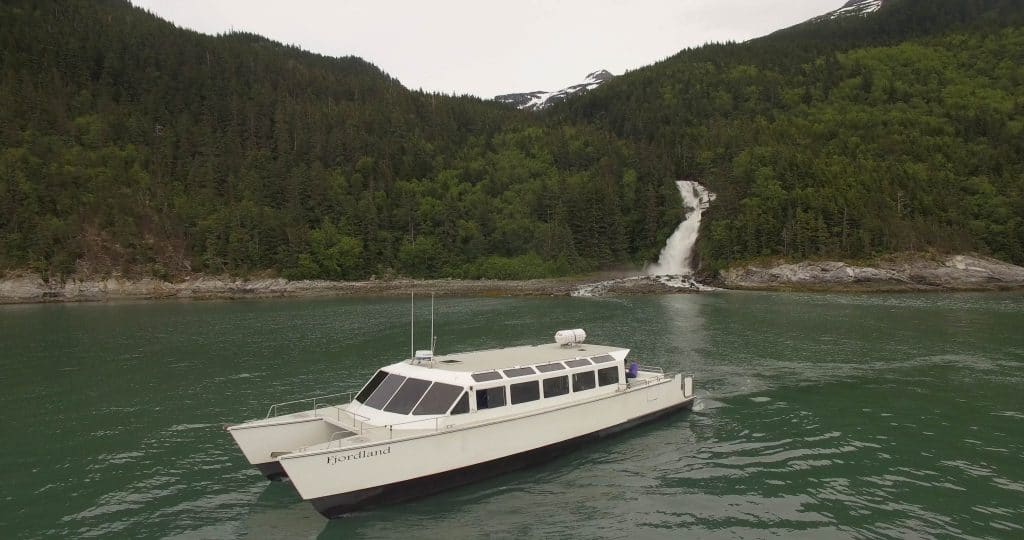 a catamaran in front of a waterfall