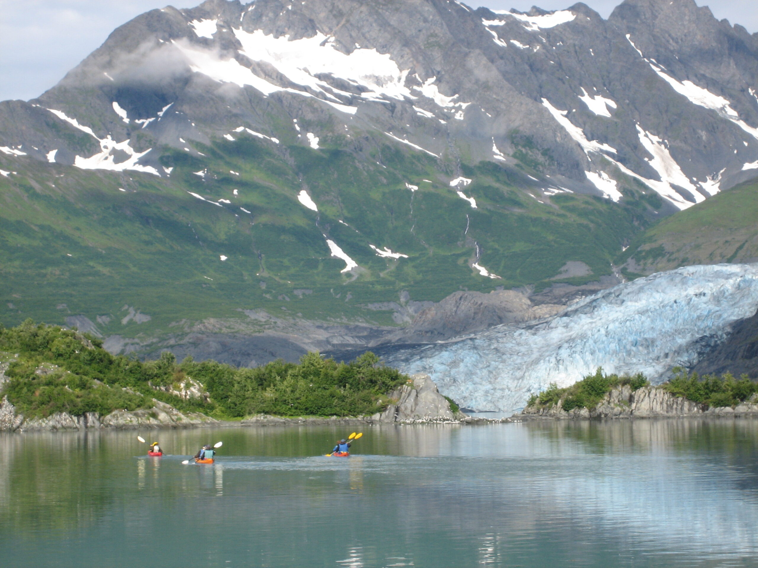 Kayaks in front of amazing scenery with a glacier in the background