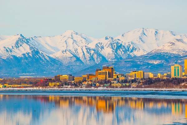 Anchorage skyline warm colors in front of snow capped mountains