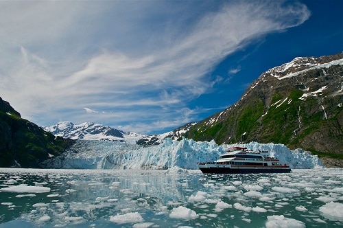 Boat from the side in an ice field in front of a glacier credit Phillips Cruises