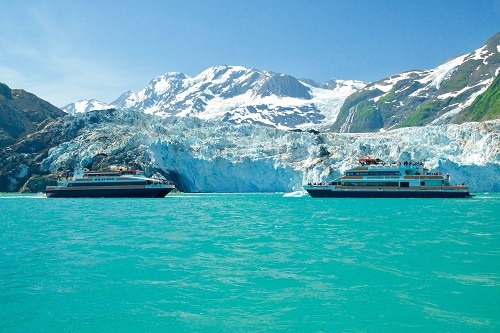 Two boats meeting in front of a glacier