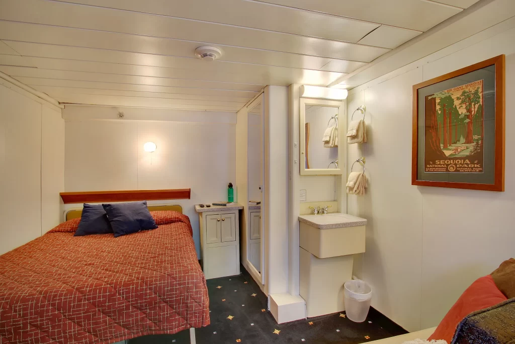 Wilderness Adventurer ship cabin one bed orange blanket sink in room
