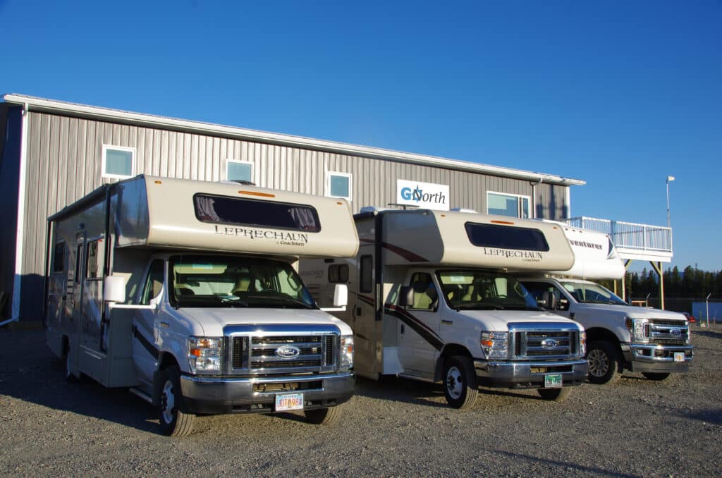 Two motorhomes and a truck camper in front of the GoNorth Yukon rental station.
